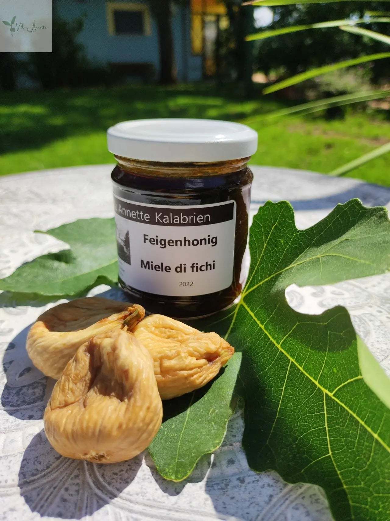 Feigenhonig 220 ml jar with figs and fig leaf on a table.